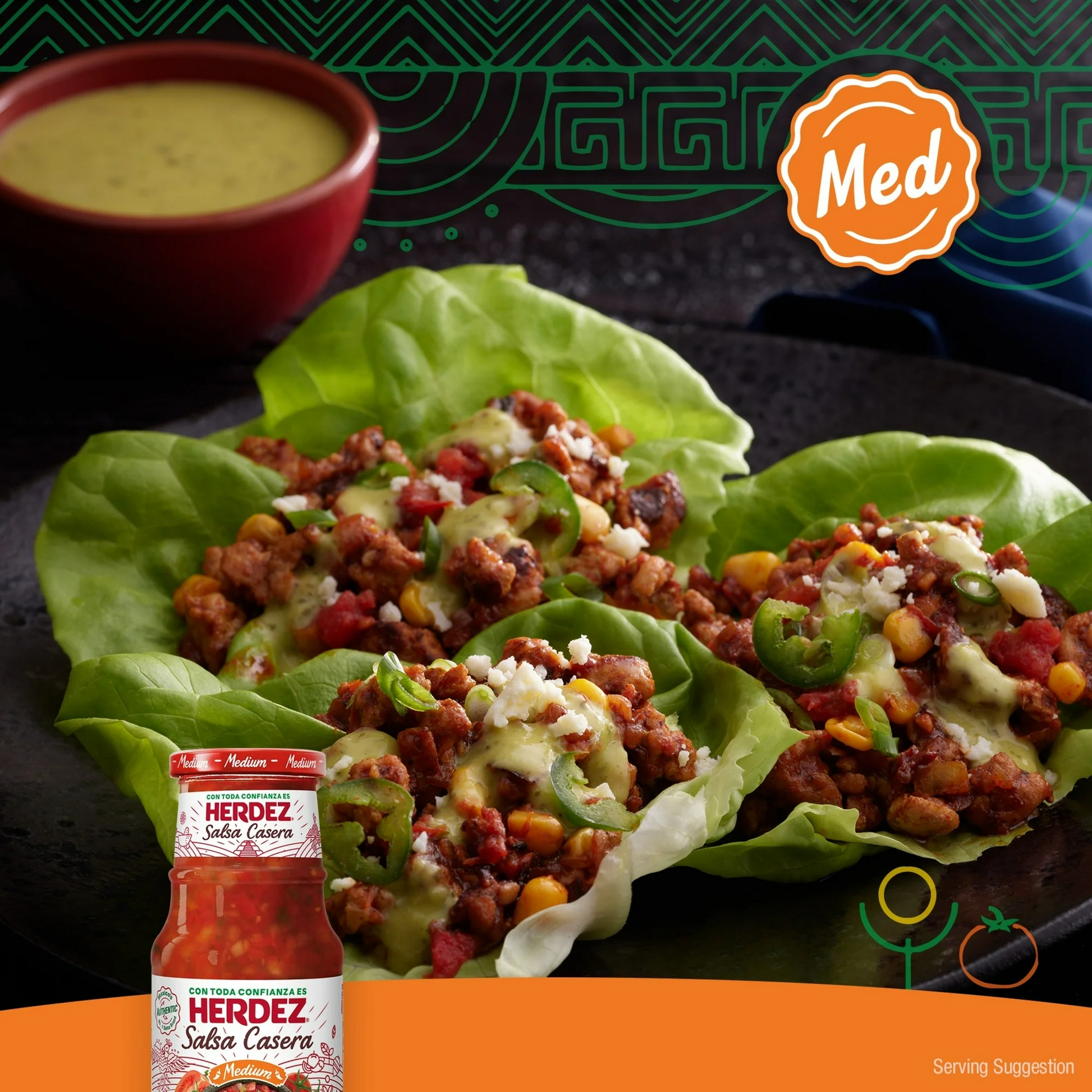 Taco lettuce wraps with Herdez Salsa Casera on a dark surface with a bottle of salsa.